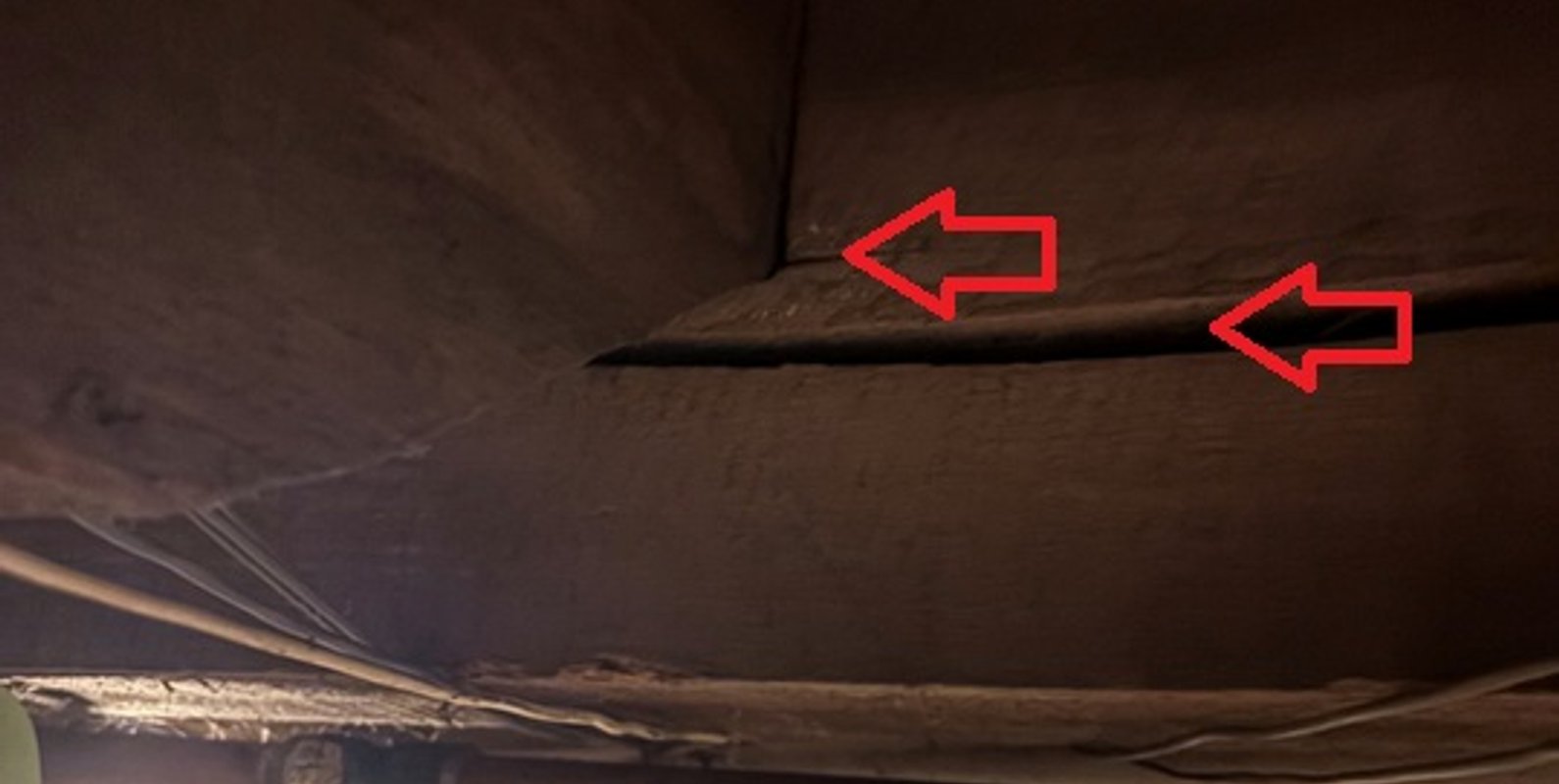 Close‑up view of a main basement beam showing early‑stage cracking at joist bearing locations, indicating overstressed load conditions identified during a structural engineering visual inspection by NextBLDG in Kirkville, New York.